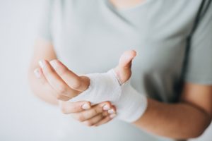 women holding hand wrapped in bandages 