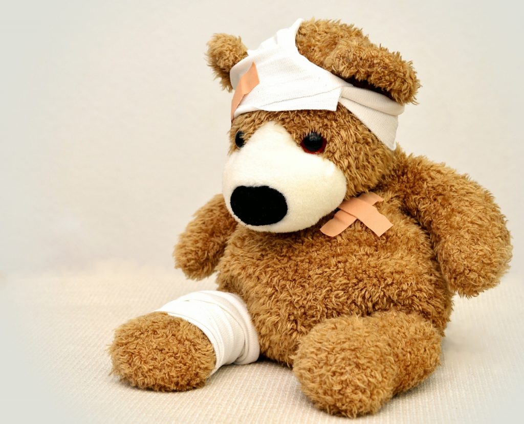 teddy bear with plasters and bandages over its body